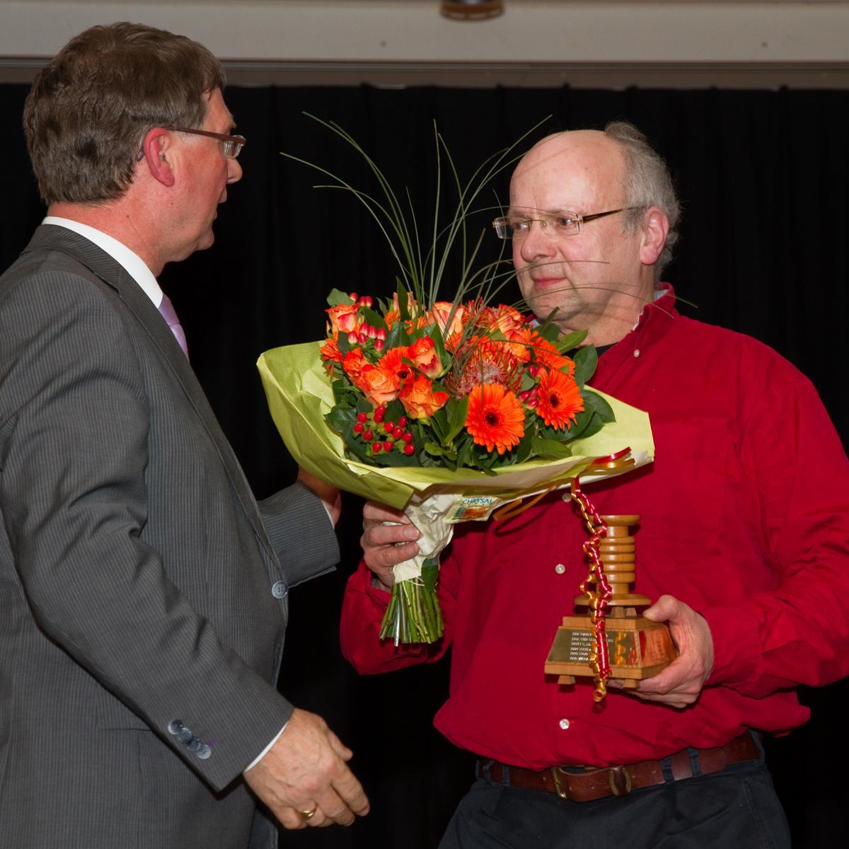 Peter vd Weijer krijgt bloemen overhandigd door de wethouder van Sport, Bart Eijkemans